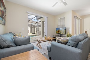 A modern living room with a sofa set, a coffee table, and a TV. - Storey Lake 4 Bedrooms near Disney Orlando FL 3079 (Kissimmee)