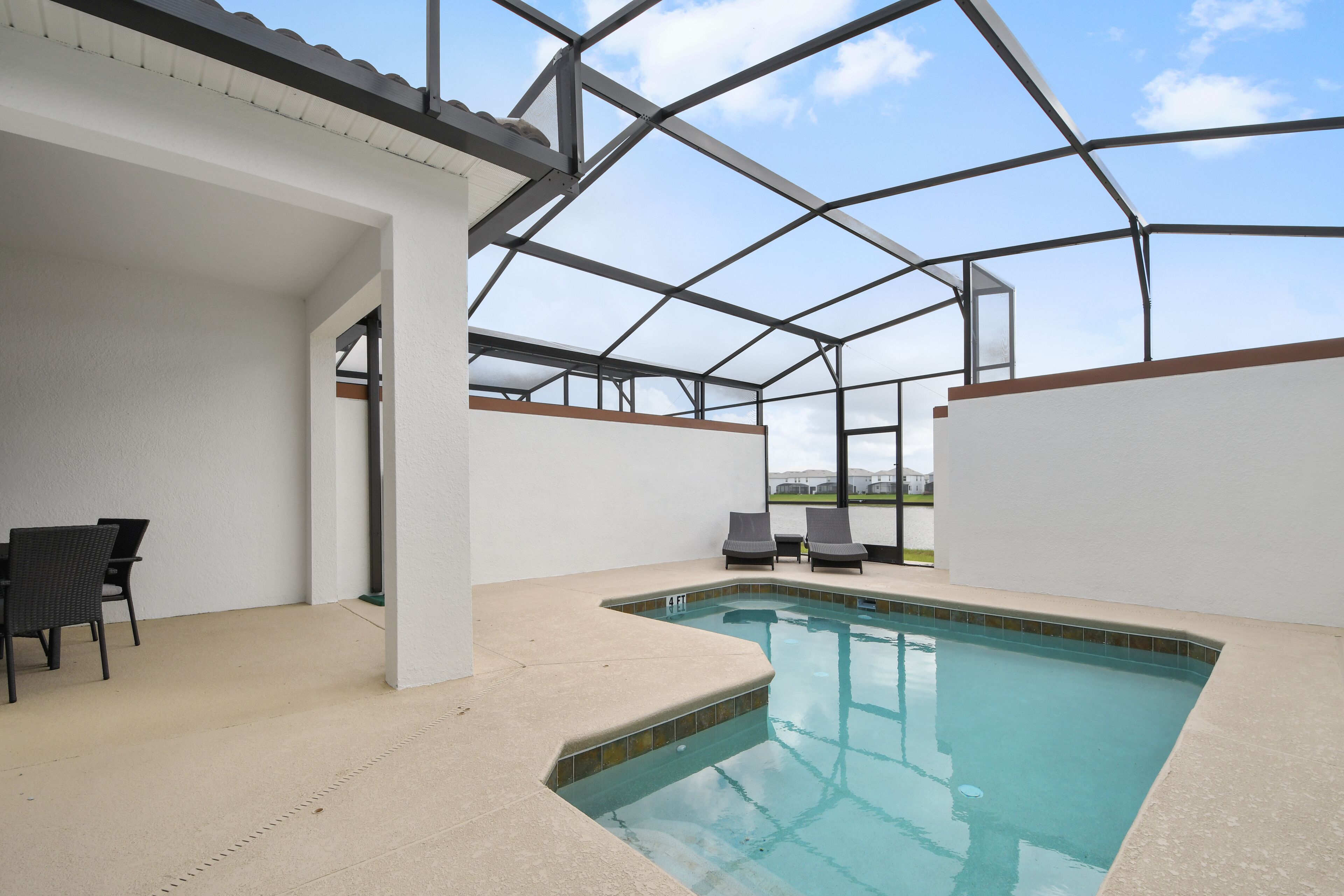 An indoor swimming pool with a glass ceiling, surrounded by white walls and a beige floor.