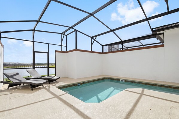 An indoor swimming pool with a glass ceiling, two lounge chairs, and a view of a distant landscape. - Charming 4Bd w/ Pool @ Storey Lake Resort Orlando 4861 (Kissimmee)