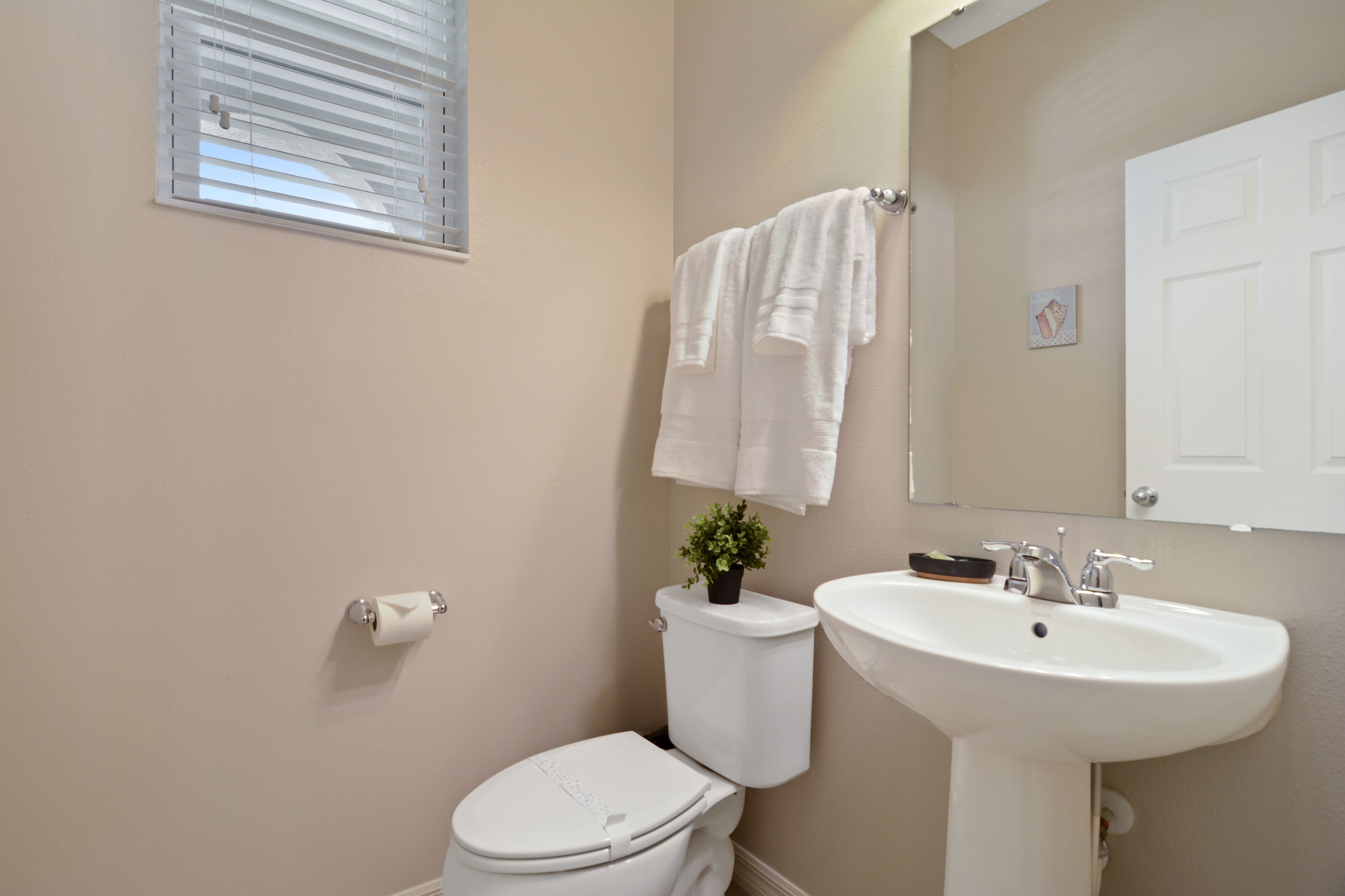 Un baño con inodoro, lavamanos y toallero.