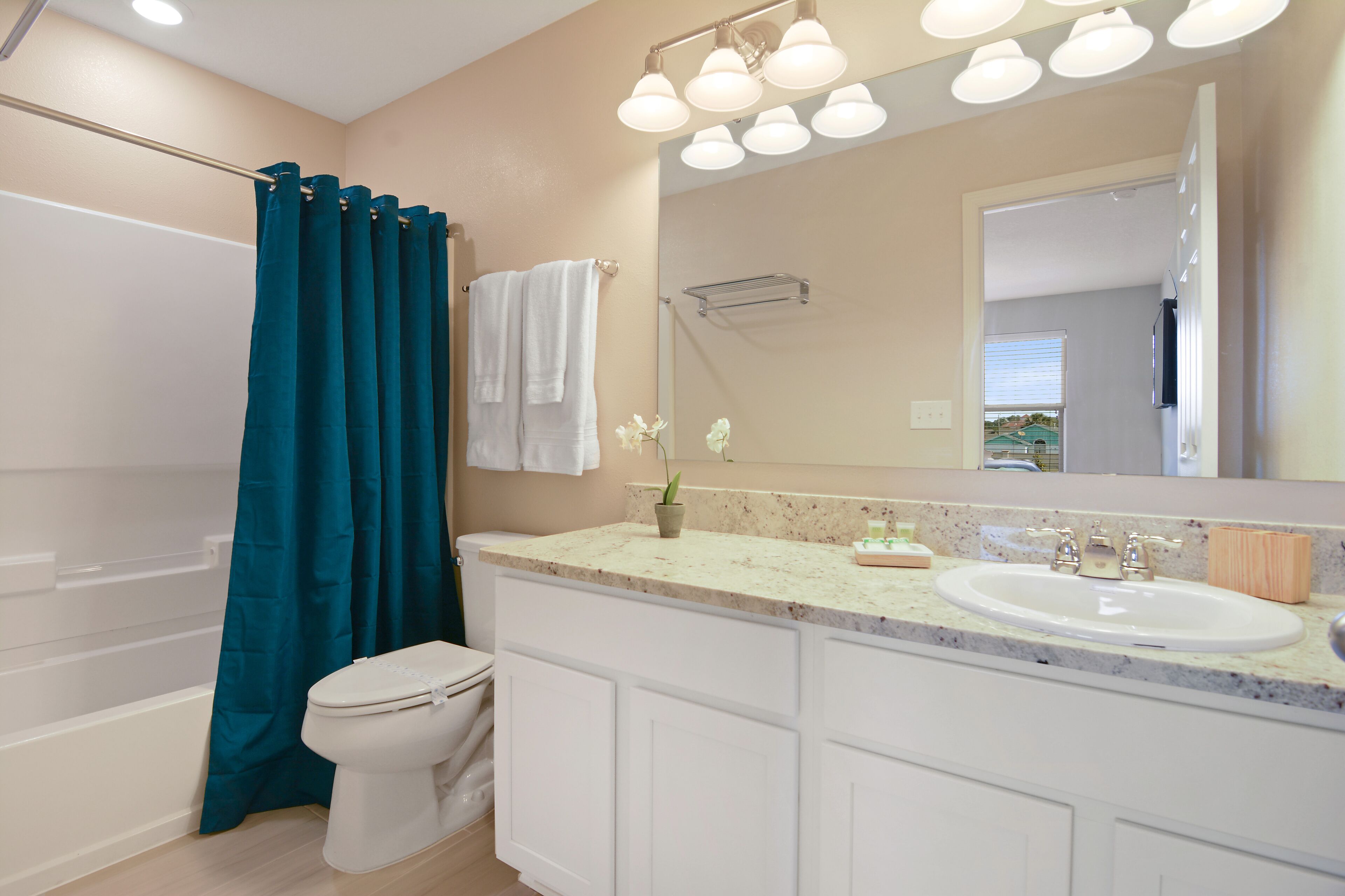 A bathroom with a bathtub, toilet, sink, and mirror.