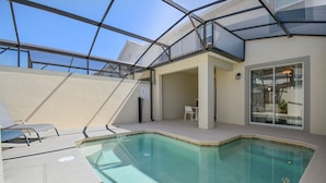 Ein Hallenbad mit großen Glaswänden, eine sonnige Terrasse mit Sitzgelegenheiten und Blick zum Himmel.
