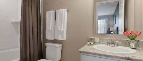A bathroom with a toilet, sink, and bathtub.