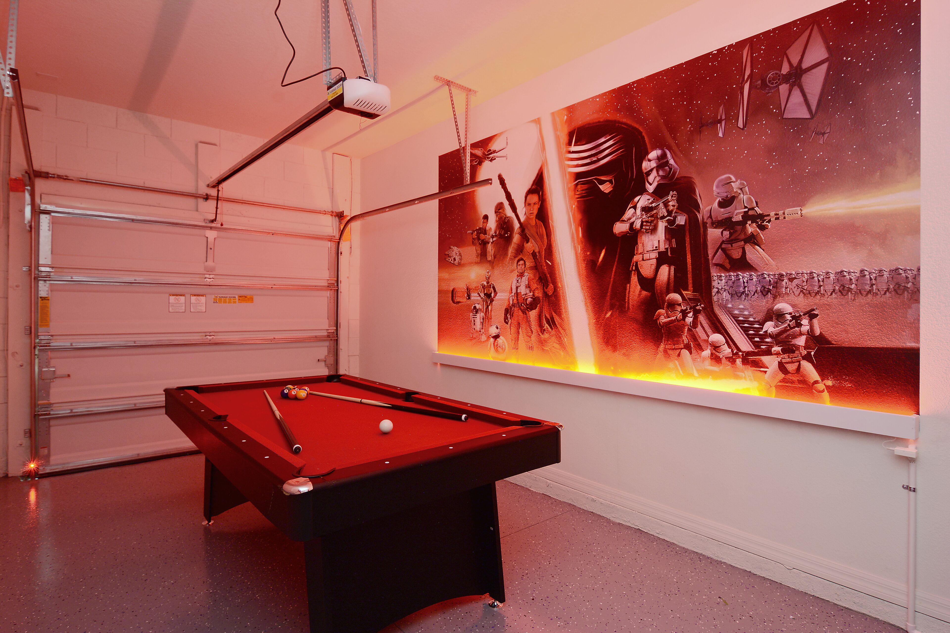 Une table de billard dans une pièce dont le mur est décoré d’une fresque murale sur le thème de Star Wars.