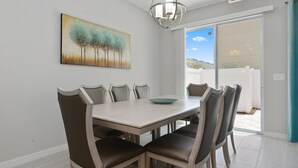Un coin repas avec une table et des chaises, un tableau au mur et un panneau indiquant la sortie.