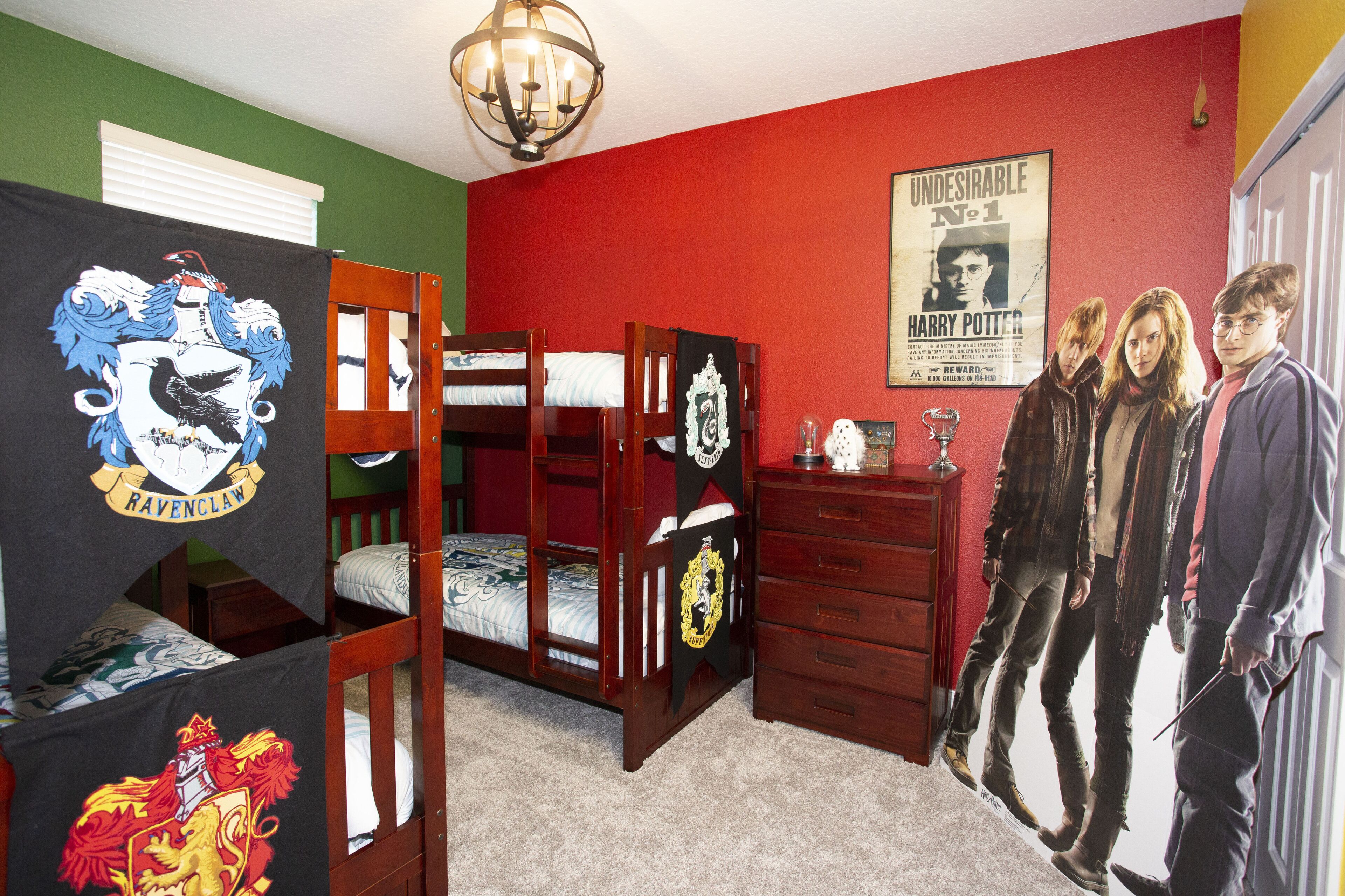 Ein Zimmer mit Etagenbetten, einem Schminktisch und einer Deckenleuchte. Ein Harry-Potter-Poster ist an der Wand.