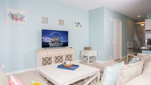A living room with a TV, a dining table, and a sofa. - Marvelous 4 Bedroom w/ Pool @ Festival Resort 197 (Davenport)