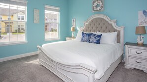 A bedroom with a large bed, two bedside tables, a window, and a view of a yellow building. - Marvelous 4 Bedroom w/ Pool @ Festival Resort 197 (Davenport)