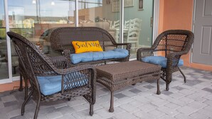 Wicker furniture with cushions, a glass door, and a view of buildings. - Marvelous 4 Bedroom w/ Pool @ Festival Resort 197 (Davenport)