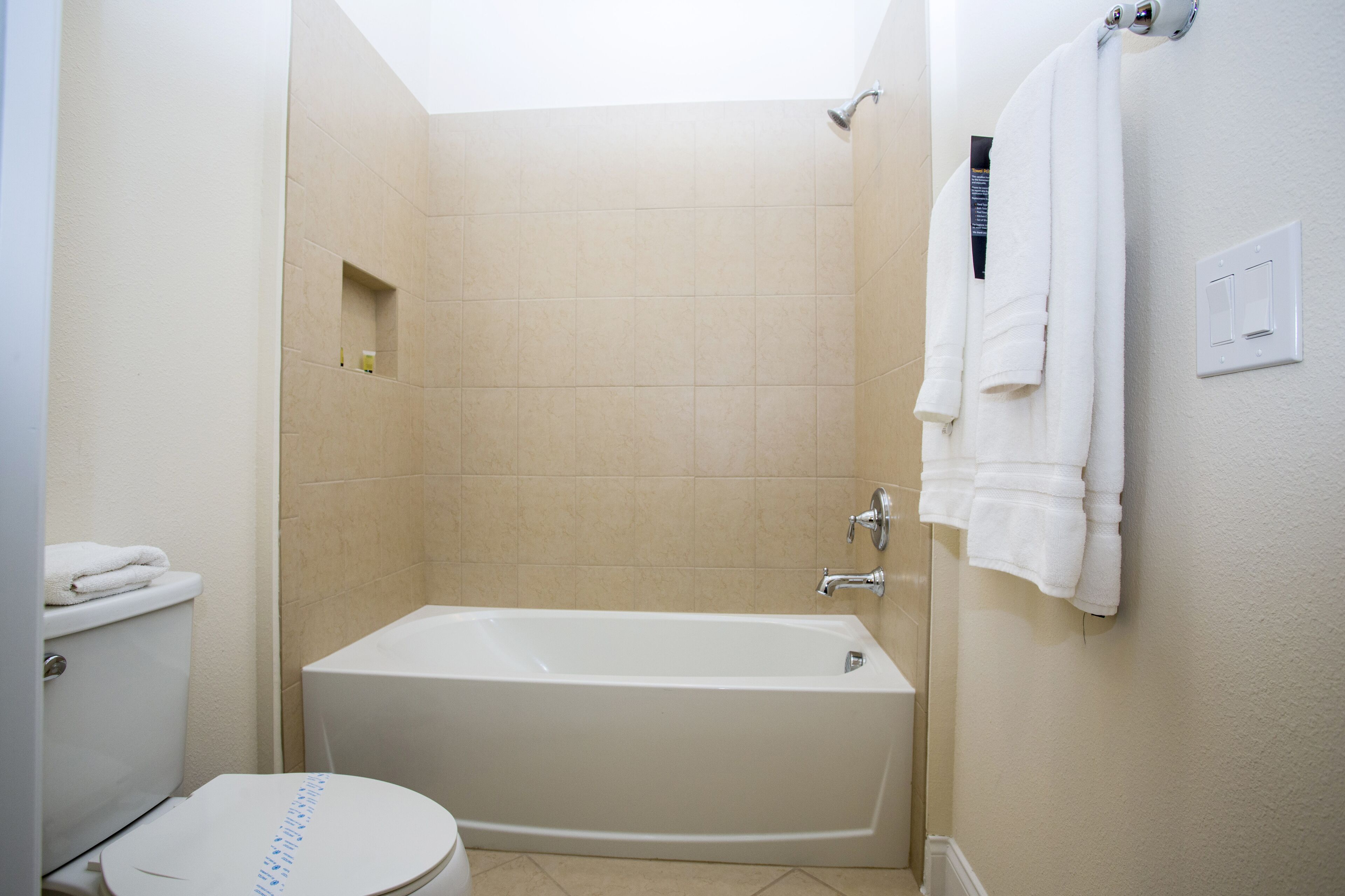 A bathroom with a bathtub, toilet, and a shower area.
