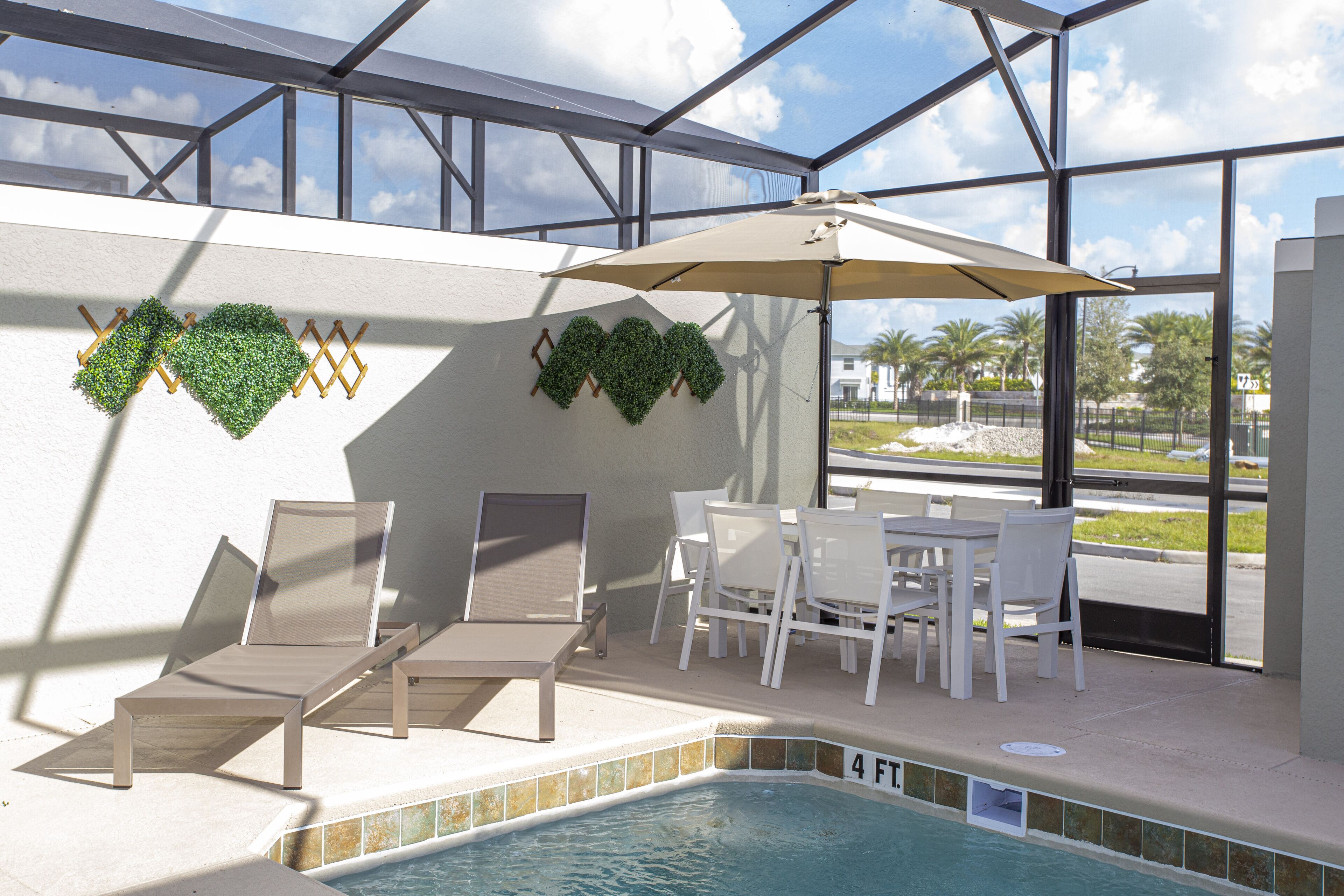 An indoor pool area with lounge chairs, a table, and chairs.