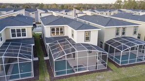 Ein Wohngebiet mit modernen Häusern, die große Wintergärten und einen Swimmingpool haben.