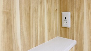 A wooden wall with a white electrical outlet and a white shelf. - bnb+ Osaka Shinsaibashi - Hostel (Osaka)