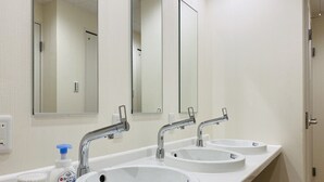 A bathroom with three sinks, a mirror, and a bottle of hand soap. - bnb+ Osaka Shinsaibashi - Hostel (Osaka)
