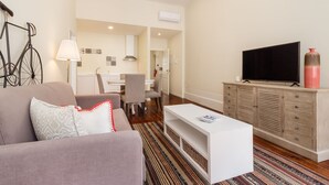 Een moderne woonkamer met een bank, een salontafel, een televisie en een kast.