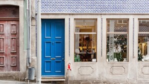 Un bâtiment avec une porte bleue, une fenêtre décorée pour Noël et un poteau métallique.