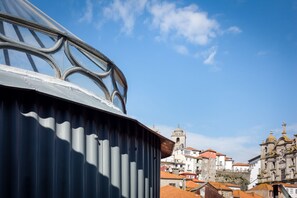 A view of a historic building with a bell tower and domed structures, viewed from a covered area with metal railings. - Nada06 · Faisama Apartments Duplex With 2 Bedrooms (Porto)