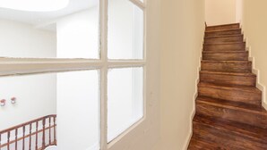 Una escalera con peldaños de madera y una puerta blanca con paneles de vidrio.