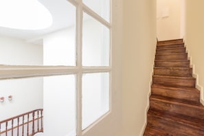 Staircase with a wooden handrail and large window.