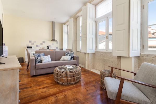 Relax in this spacious living area with a large sofa, wicker ottoman, and comfortable chair.