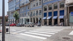 A multi-story building with blue-tiled facades, a pedestrian crossing, and a street lamp. - Nada02 · Faisama #2 Studio Next to Ribeira (Porto)