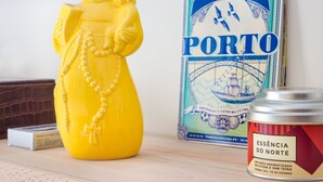 Une figurine jaune, un livre intitulé « CONVIDA PORTO » et un bocal étiqueté « ESSÊNCIA DO NORTE ».