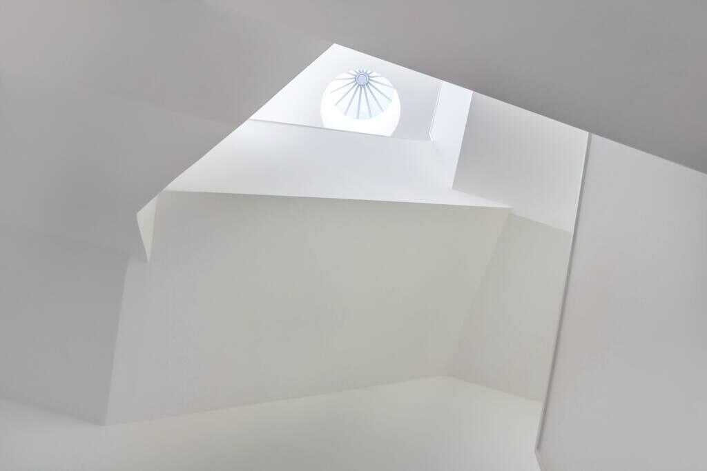 A room with a skylight and a simple, modern design.