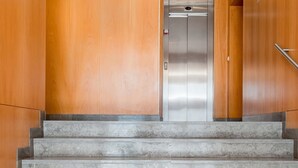 A set of marble stairs leading to an elevator in a building with wooden paneling. - Mat001 · Bohemian Vibe at a Fresh Coastal Getaway (Matosinhos)