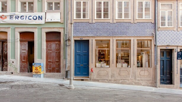 A street view with a building labeled 'ERGICON' and another with a blue door and windows displaying items inside. - Nada01 · Cute and Simple Apartment in the Historic District (Porto)