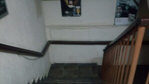 A staircase with a wooden handrail and a tiled floor. - Addis Lodge (Gilgil)
