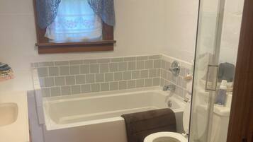 Bathtub, towels, soap, toilet paper