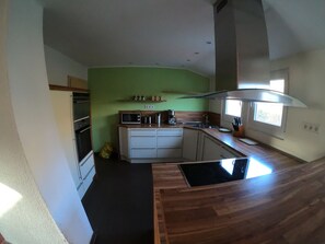 A compact kitchen with a microwave, coffee maker, and sink. - KraftQuelle (Kirchen)