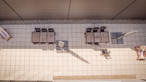 A tiled wall with three wooden planters and two signs. - Hotel Garni Fischerfleck (Ismaning)