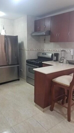 Enjoy casual dining and socializing in this kitchen with ample workspace and a convenient bar area.