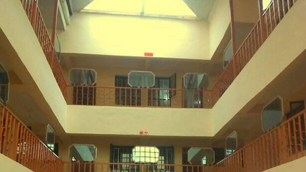 A multi-level atrium with a checkered floor, balconies with railings, and a central open space. - The Delta Falls Hotel (Nyahururu)