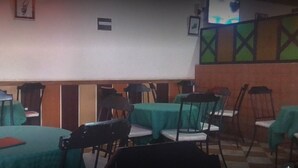 A restaurant with tables covered in green tablecloths and chairs. - The Delta Falls Hotel (Nyahururu)