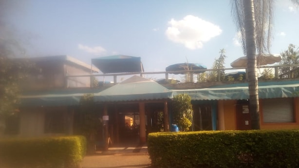 A building with a covered entrance and a paved pathway leading to it. - Sun Citi Resort (Sagana)
