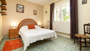 A bedroom with a bed, a chair, a window with curtains, a radiator, and a wall with pictures. - Stunning private villa for 6 guests with A/C, private pool, WIFI, TV, terrace and pets allowed (Calpe)