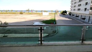 A view from a balcony overlooking a street with a building in the background. - Residence Yasmine Mdiq 4691 (Mdiq)