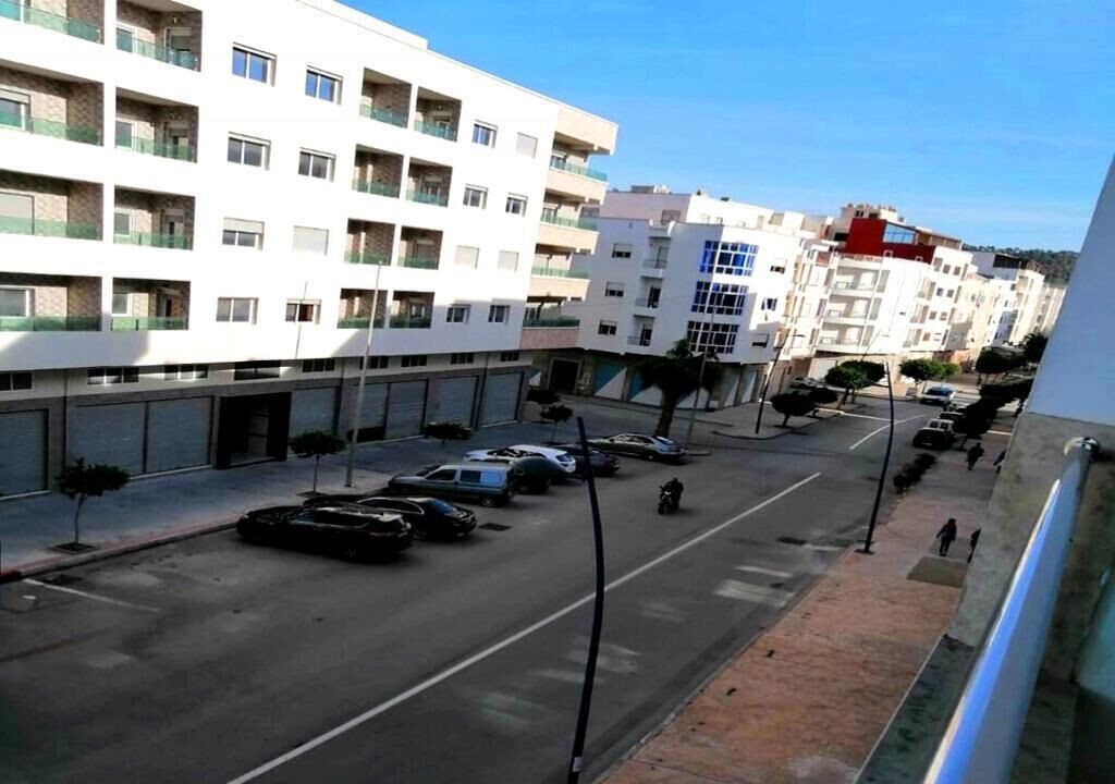 A multi-story building with a modern architectural style, featuring balconies and a flat facade.