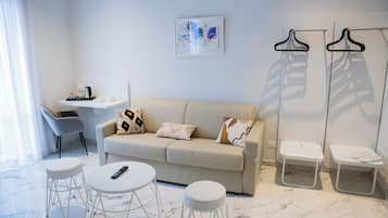 Suite estudio, vista a la ciudad | Área de sala de estar | Smart TV de 49 pulgadas con canales digitales, televisión y Netflix