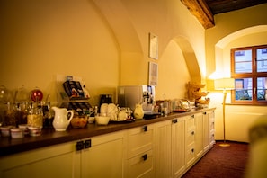 A kitchen with white cabinets, a wooden countertop, and various kitchen items. - Pension Donatus (Pirna)