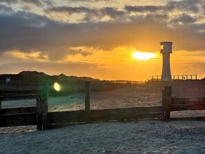 A lighthouse by the sea during sunset. - East Beach Guest House (Littlehampton)