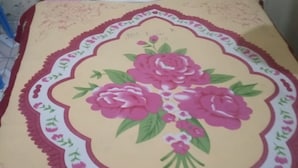 Una cama con colcha estampada y almohada blanca.