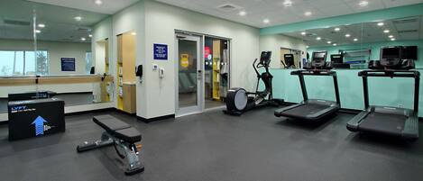 A gym with treadmills, a stationary bike, and a weight bench.