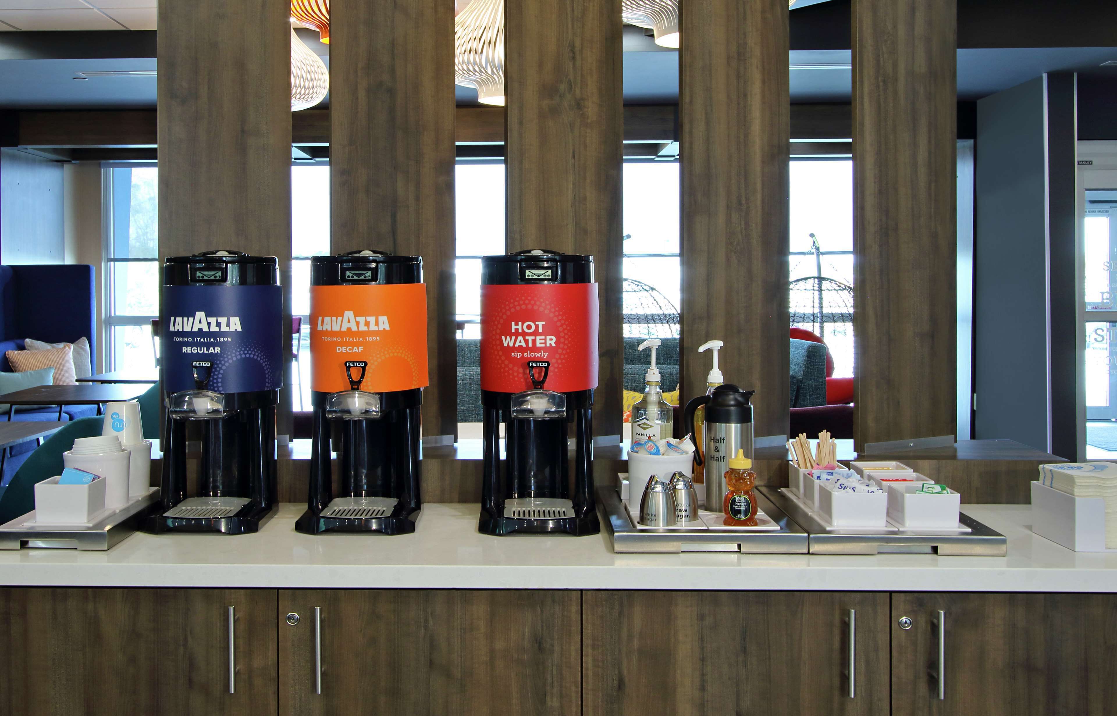 A coffee station with three coffee dispensers labeled 'Lavazza' and 'Hot Water'.