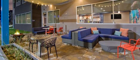 An outdoor seating area with a fire pit, sofas, and chairs.