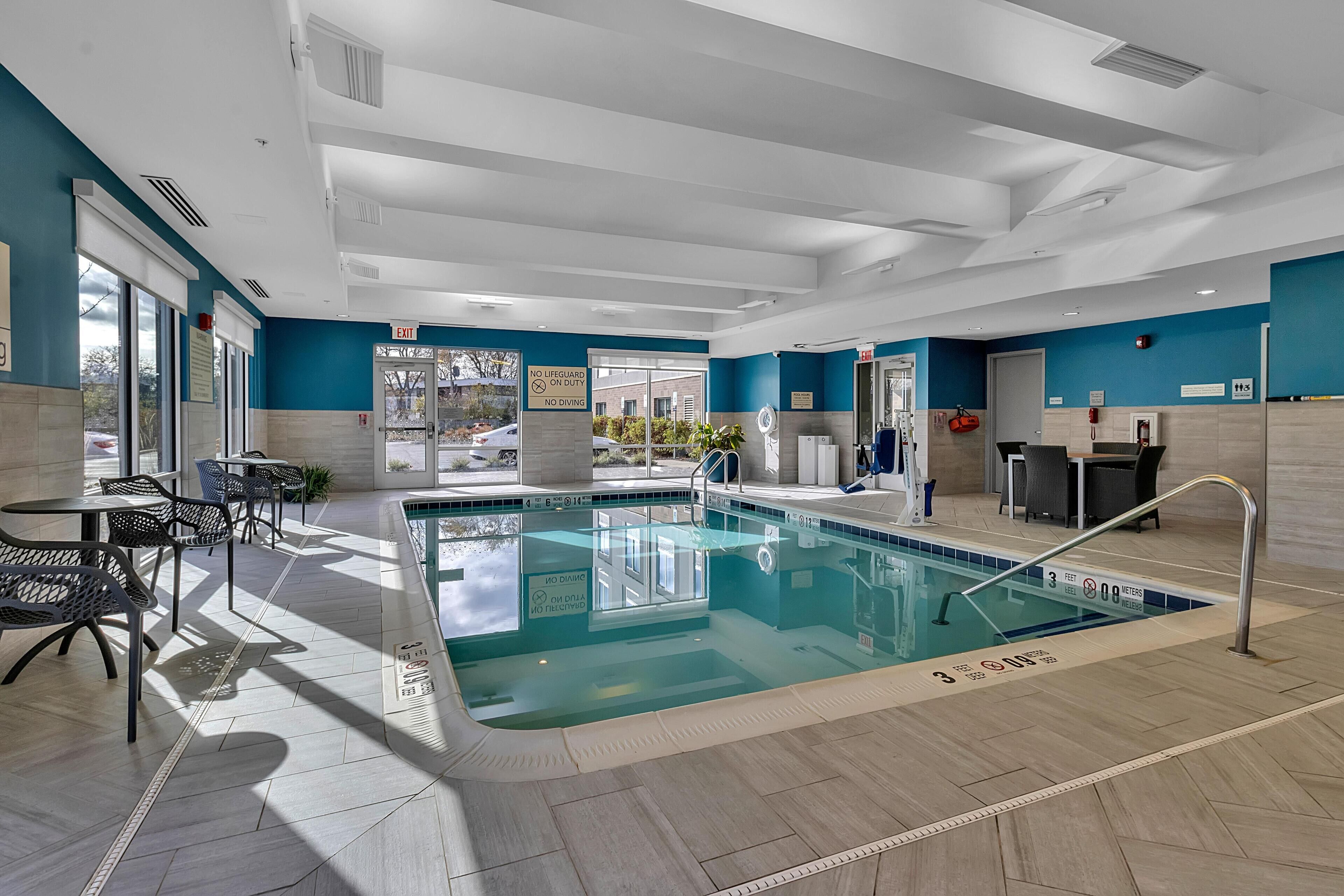 Una piscina techada, sillones reclinables de piscina