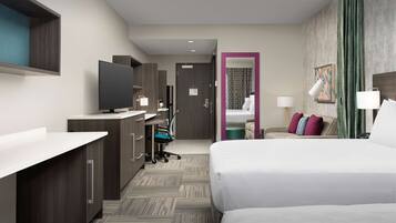 A hotel room with a bed, a desk with a computer, a TV, and a bathroom visible through an open door.