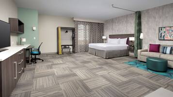 A hotel room with a bed, a desk, a chair, a wardrobe, and a television.